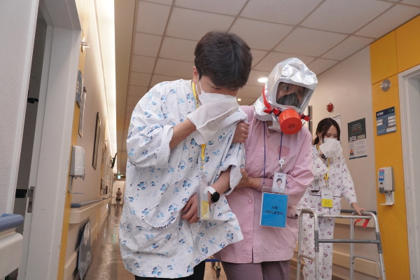 분당서울대병원이 분당소방서와 합동으로 실시한 화재 대응훈련에서 간호사 및 직장자위대가 환자를 부축해 이송하고 있다